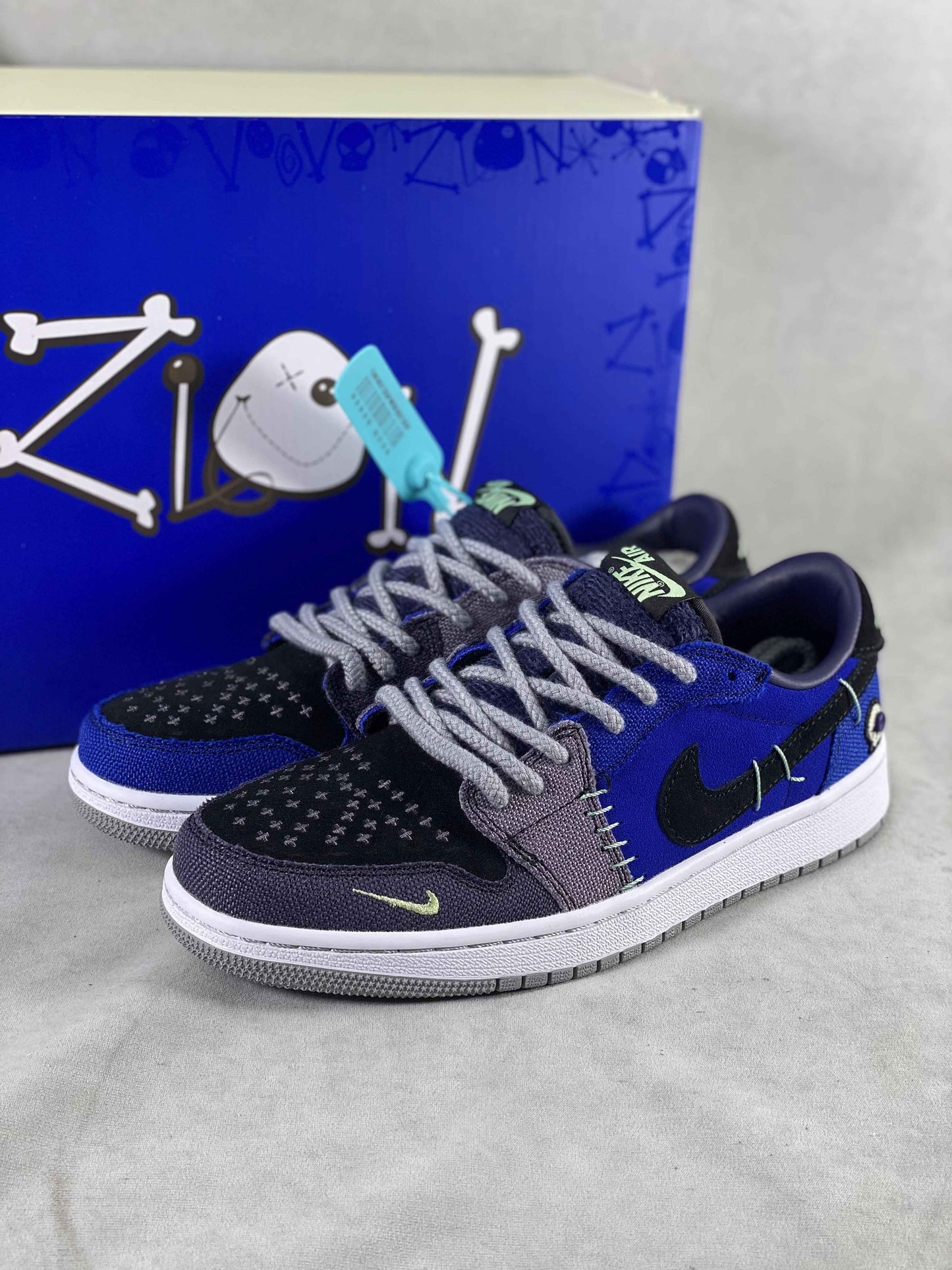 Luxury urban wear designer sneakers in black and blue with unique stitching, showcased in front of a blue box with a playful graphic, perfect for premium street style collections.