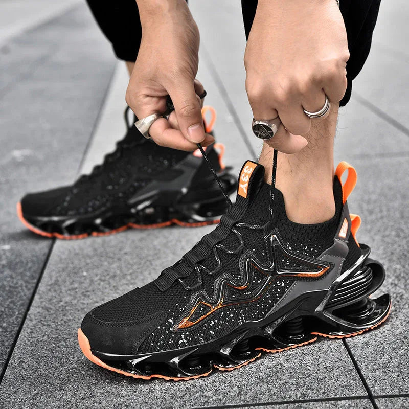 Man tying laces of Nova Sole T84 Sneakers in black and orange on pavement - LUXURYURBANWEAR urban sneakers.