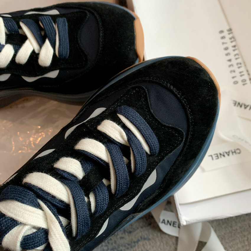 Women's black and navy round toe lace-up sneaker with white accents on urban wear box