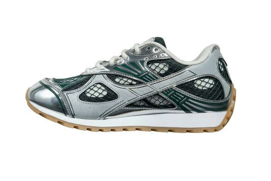 Gray and green sneaker with a white sole on a gray surface and light gray background