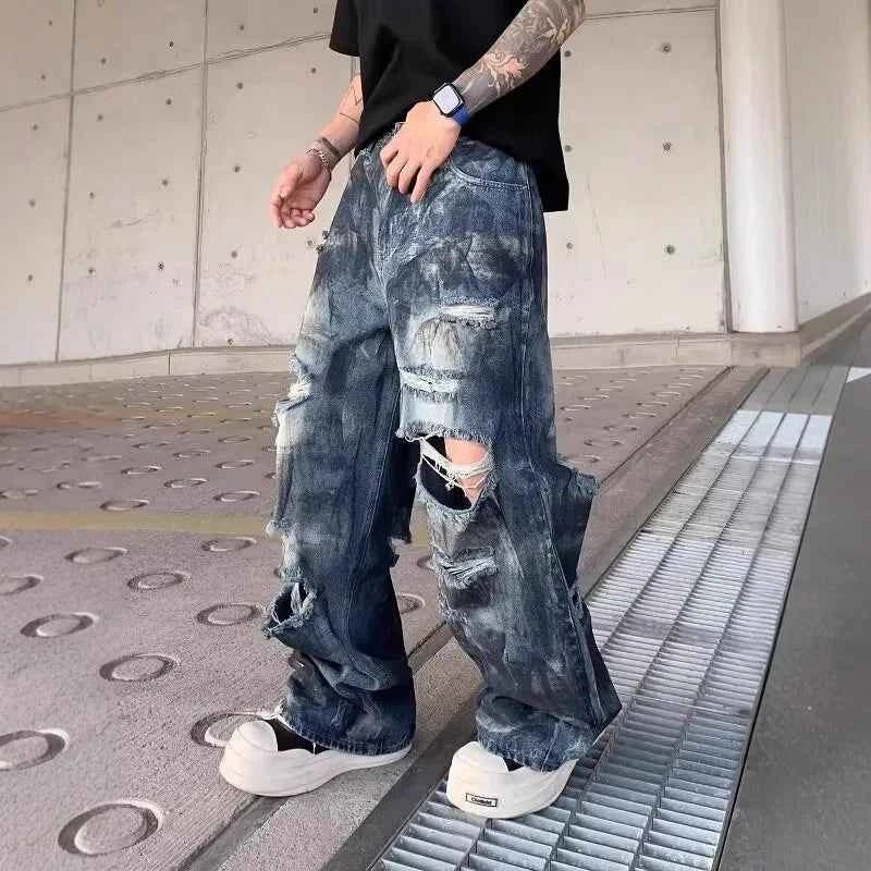 Front view of model wearing vintage distressed ripped blue denim jeans with baggy fit