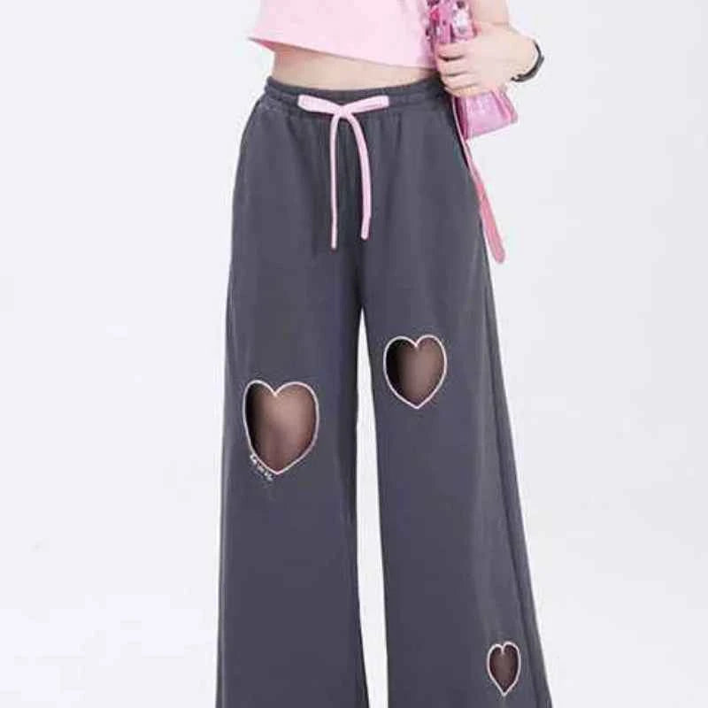Front view of model wearing pink sweet vintage love high waist baggy sweatpants with heart embroidery