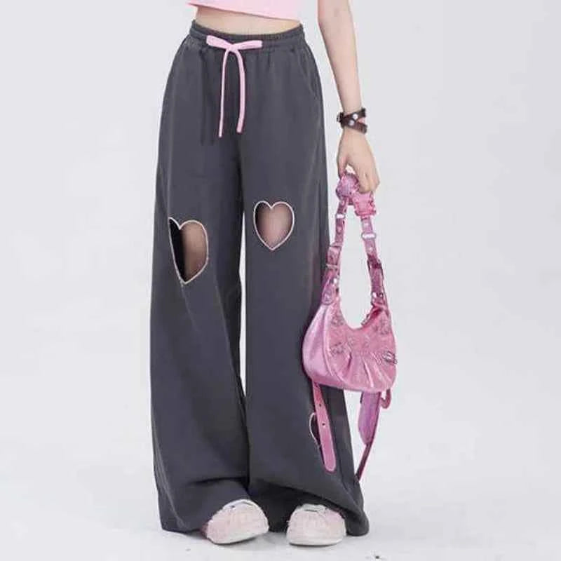 Front view of model wearing pink sweet vintage love high waist baggy sweatpants with heart embroidery