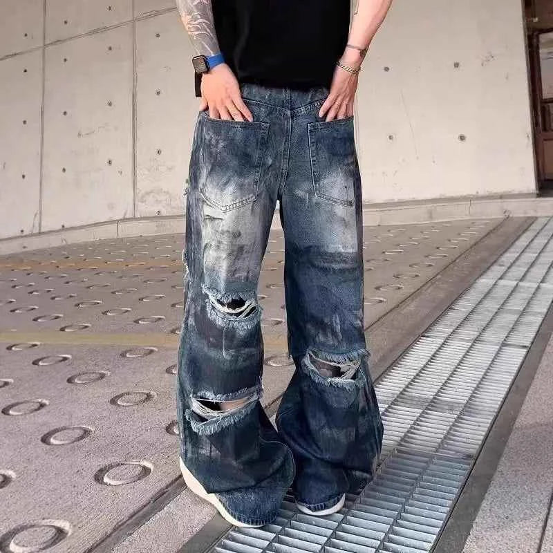 Front view of model wearing vintage distressed ripped blue denim jeans with baggy fit