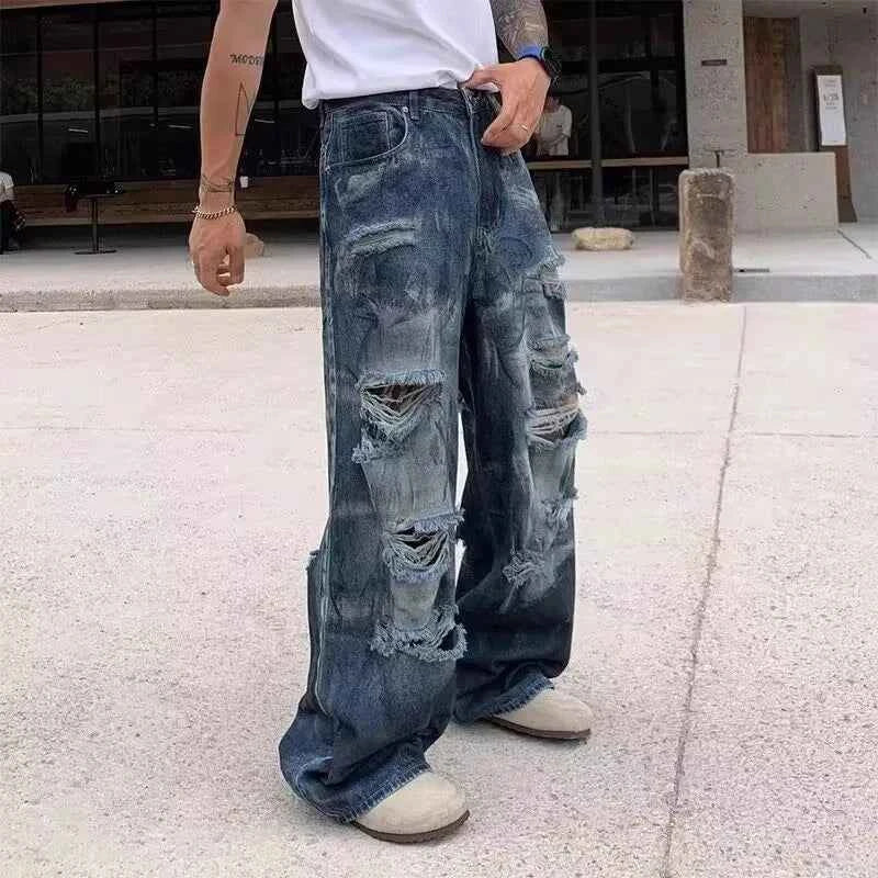 Front view of model wearing vintage distressed ripped blue denim jeans with baggy fit