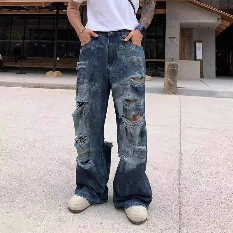 Front view of model wearing vintage distressed ripped blue denim jeans with baggy fit
