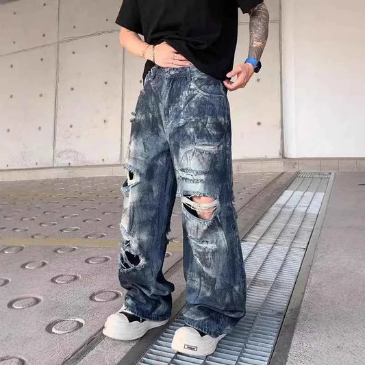 Front view of model wearing vintage distressed ripped blue denim jeans with baggy fit